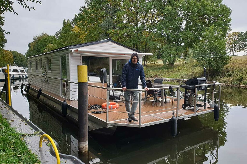 Bungalowboot liegt an der Schleusenwartestelle in der Seenplatte