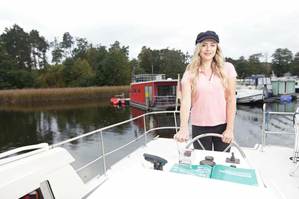 Junge Frau an Bord eines Hausbootes in Brandenburg