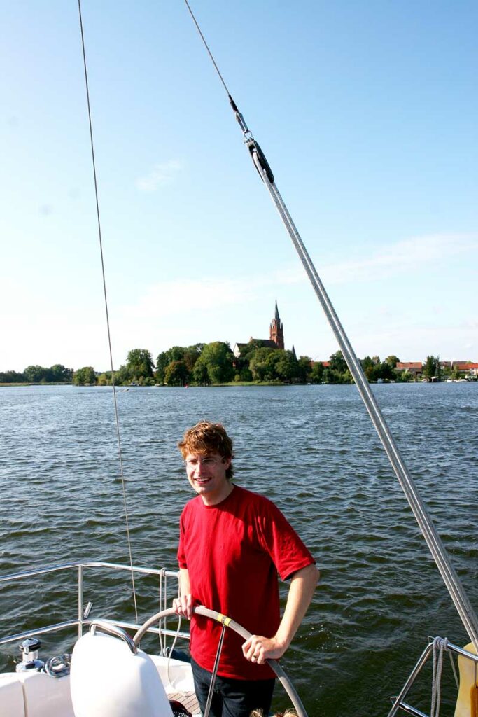 Hausboot Profi Frank in jungen Jahren am Steuer eines Segelbootes vor Röbel an der Müritz