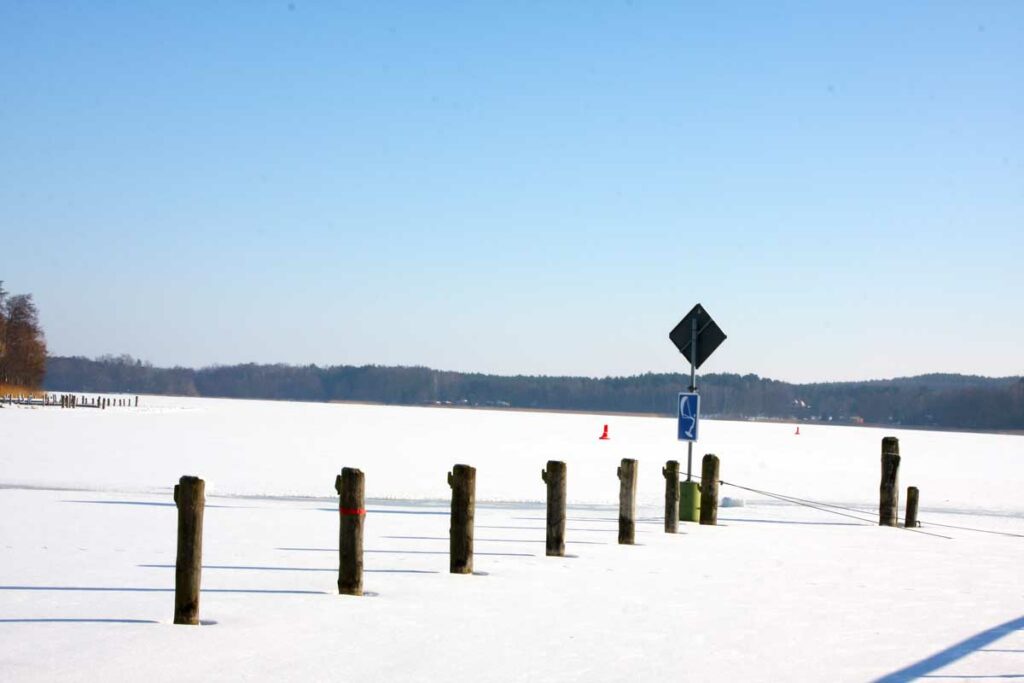 Zugefrorener See in Brandenburg mit Schneedecke und Wasserzeichen